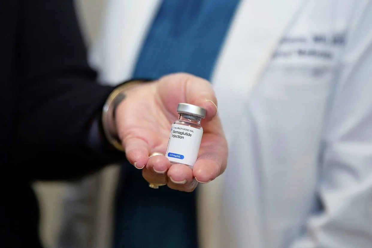 Physician holding a semaglutide injection vial, representing GLP-1 medication now covered under the Medicare GLP-1 Bridge